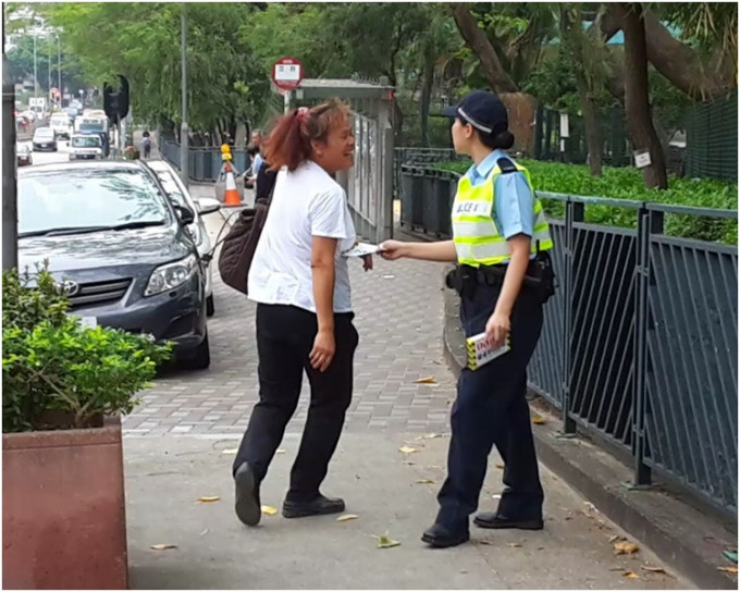 女子违规过马路被警员向她作出警告。林思明摄