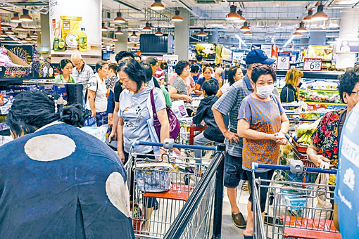 新加坡民眾上周二在一間超市內排長龍付款。　
