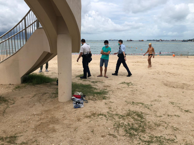 警员返回泳滩调查，发现一堆个人物品，未知是否属于死者。 梁国峰摄