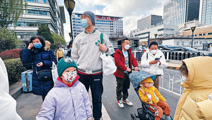 北京一间儿童医院外，大批家长带着小孩看病。