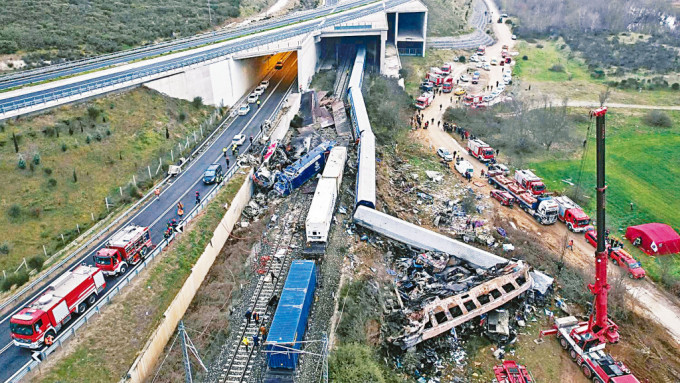 客运火车(右)与货运火车在隧道口相撞，导致多个车厢出轨。