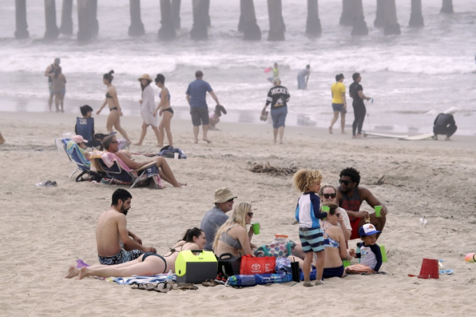 美国加利福尼亚州数万民众涌向各处海滩。AP图