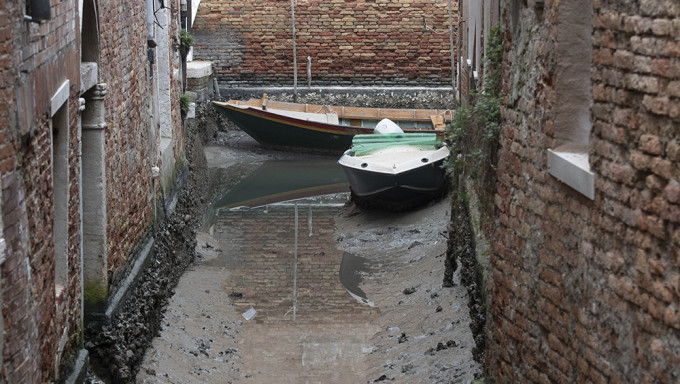 意大利威尼斯退潮期間，船隻停靠在一條乾涸的運河上。AP