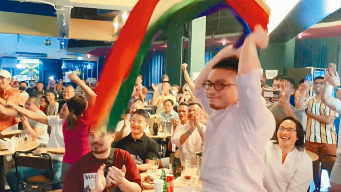 一名男子周日揮舞彩虹旗，慶祝新加坡廢除男男性行為列刑事罪行的法例。