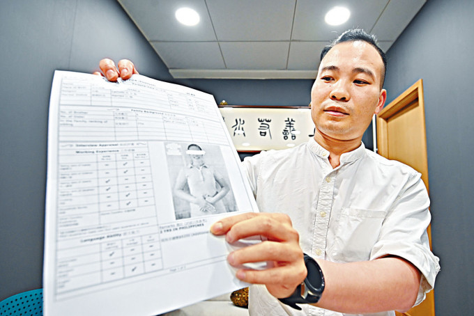 梅少峰向记者展示聘请外佣的合约和开支收据。