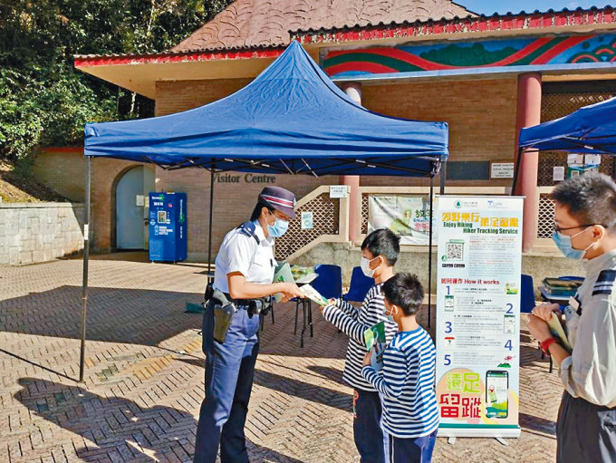 ■警方在北潭涌派發行山安全單張。