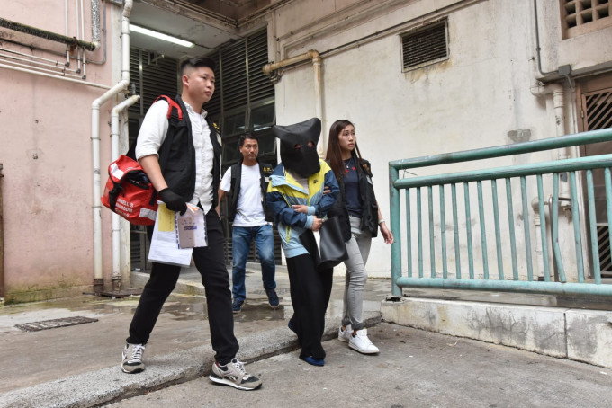 警方今午押返其中一名31岁女疑犯，到观塘翠屏北邨翠柏楼寓所搜查。杨伟亨摄
