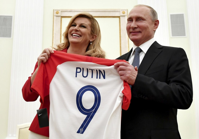 科林达向普京送上印有他名字的9号球衣。AP