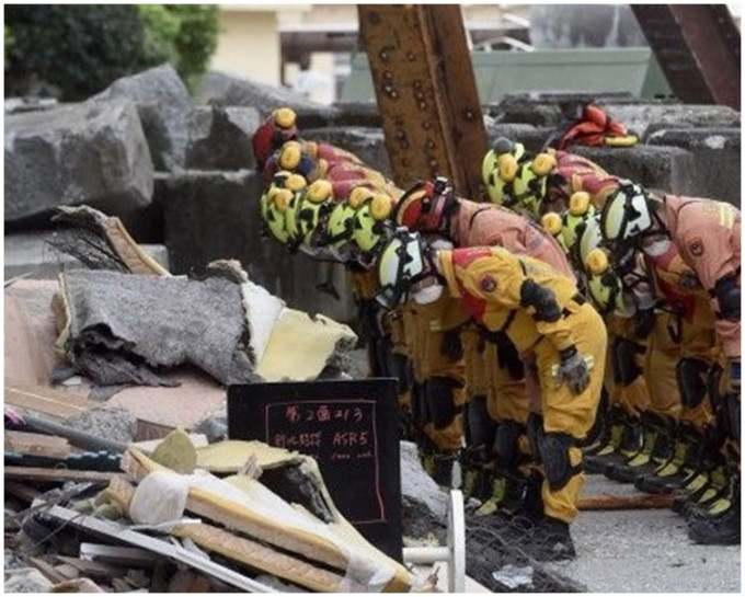 搜救人員列隊對著雲門翠堤大樓方向鞠躬。