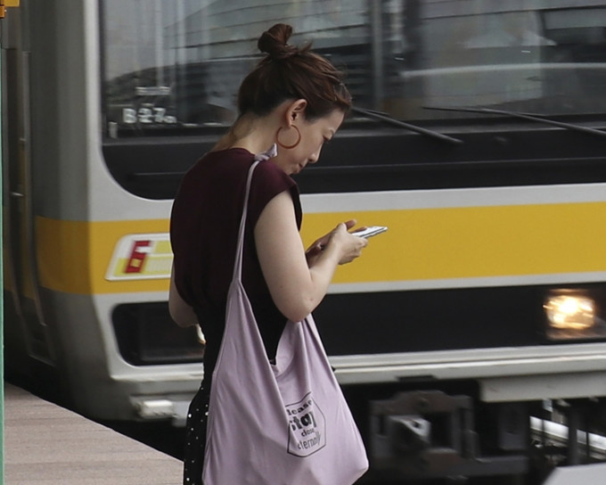 日本一名民衆使用手機。AP圖片