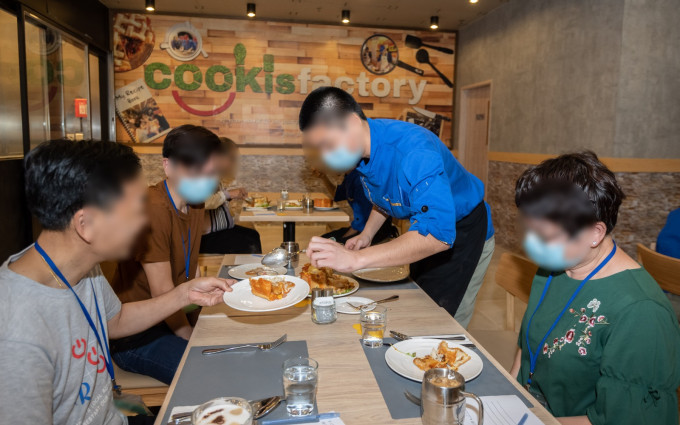 歌連臣角懲教所接受烹飪和餐飲業訓練的所員與家人一同製作並分享麵包焗豬扒飯。署方圖片