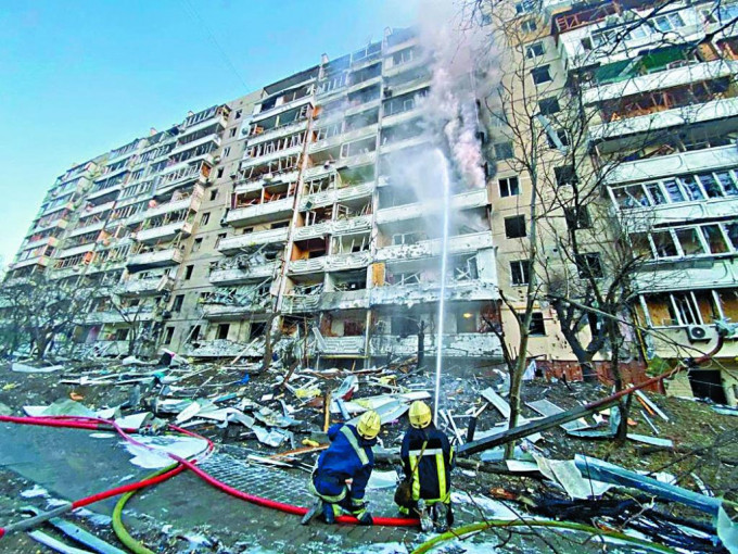 基輔一座住宅大樓遭炮火炸毀，消防員在救火。 