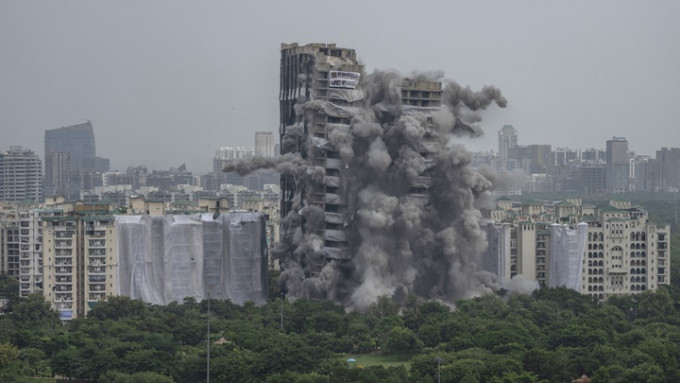 新德里郊區2幢大廈涉違建，被當局以爆破方式拆卸。AP圖片