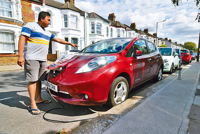 ■伦敦一名Uber司机示范如何以街边的电动车充电系统充电。