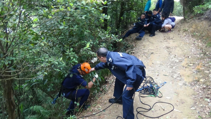 警员协助爱协人员落山救狗。