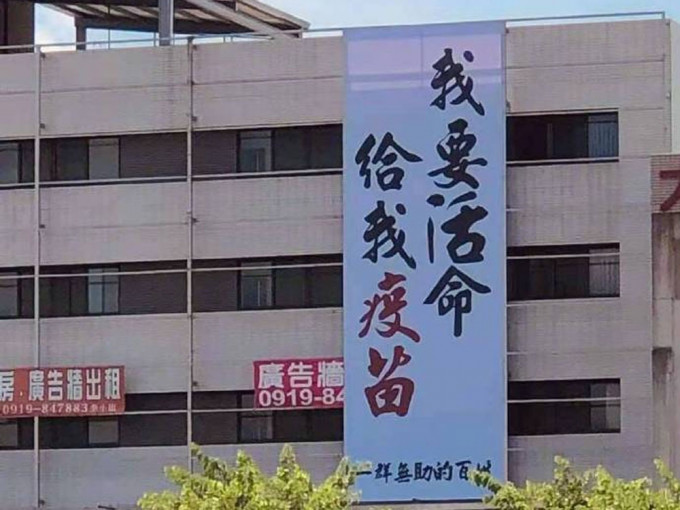 台灣民眾高樓掛「我要活命 給我疫苗」直幡。網圖