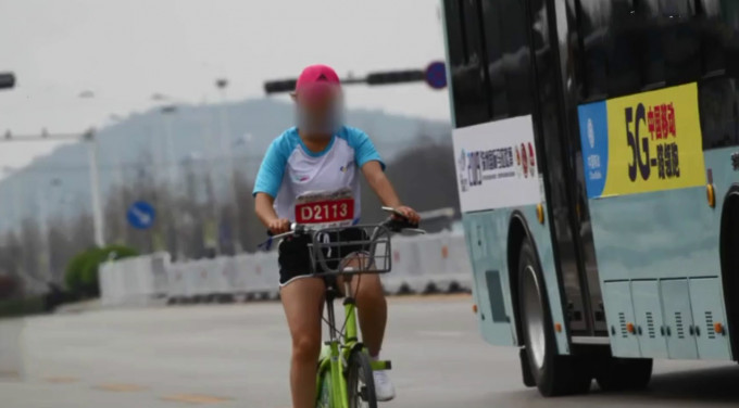 一名女選手以單車參與馬拉松賽事。　影片截圖