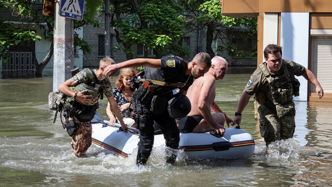 在烏克蘭赫爾松，卡科夫卡大壩決堤後，警方將當地居民從洪水氾濫的地區疏散。路透