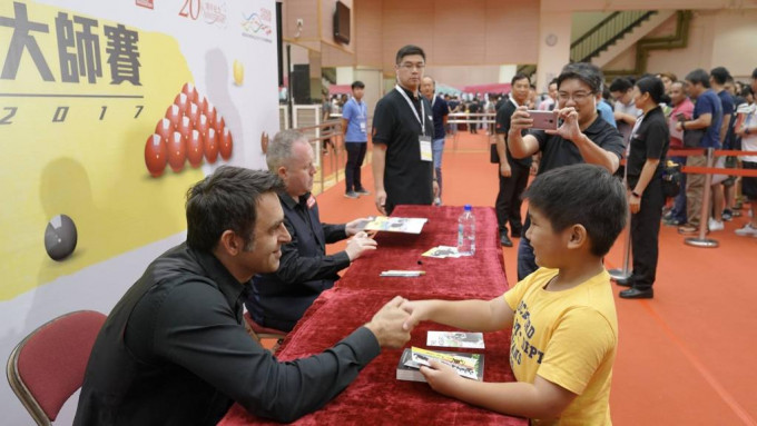 17年香港举办桌球大师赛，奥苏利云(左)现身新伊馆为小球迷签名。 香港桌球总会图片