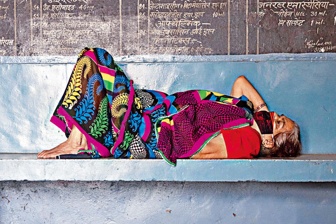一名呼吸困难的女子，在印度北方邦的医疗中心等待诊治。