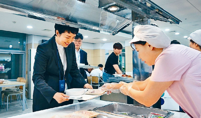 南韓總統府員工食堂周一午餐供應國產海鮮，總統室首席新聞秘書金恩慧（左）領餐。