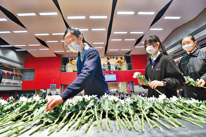 学生在悼念活动轮流上台献花，悼念南京大屠杀死难者。