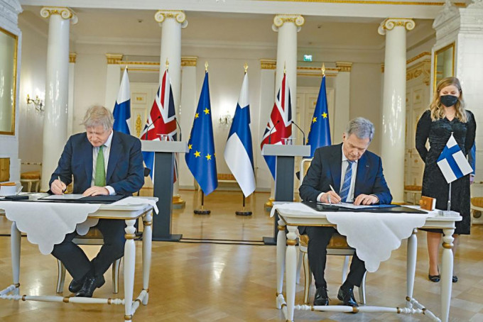 約翰遜與芬蘭總統尼尼斯托(右)周三在赫爾辛基的總統府內，簽署安全協議。