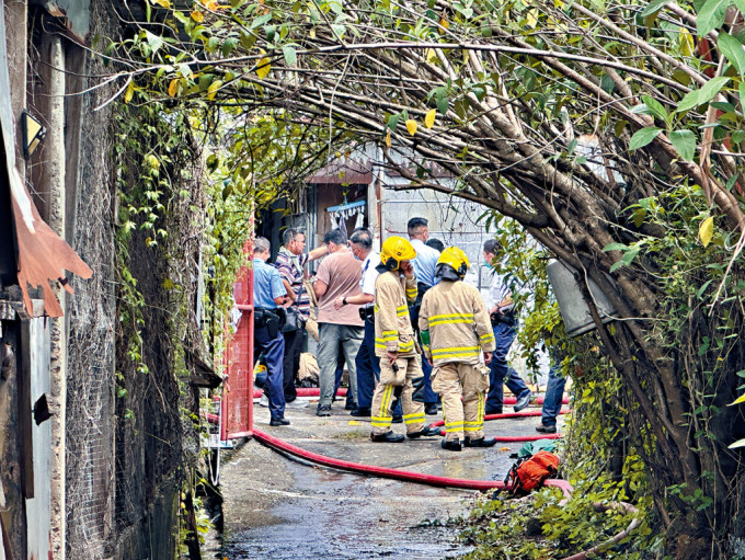 消防员将大火救熄后调查起火原因。