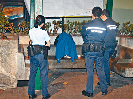 青年疑自斷手帶在荃灣吃車仔麵被揭發，瑟縮在石凳上。
