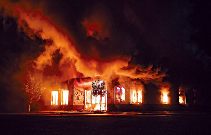 ■纳卡地区首府斯捷潘纳克特上周六遭炮轰后，一家店铺着火焚烧。