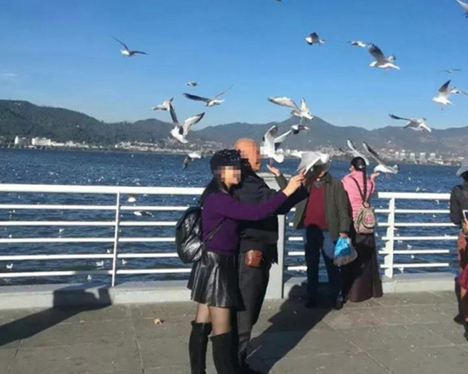 浙江一對父女抓住一隻海鷗並與其合照，被罰款約735港元。網圖