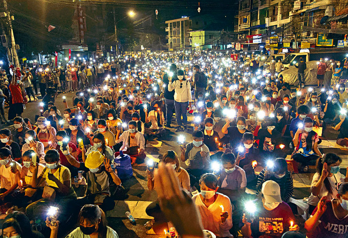 民眾周日在仰光亮起手機燈遊行，悼念遇害的反政變示威者。