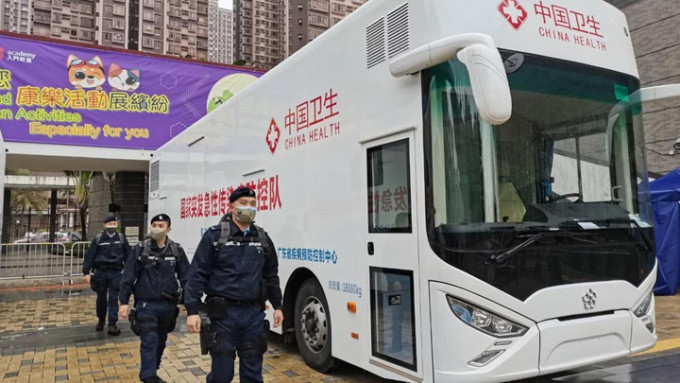 警員於內地支援香港的2輛流動檢測車旁邊巡邏戒備。警方圖片