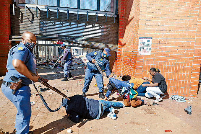 南非警察周一在豪登省凯特勒洪镇，拘捕商场抢掠者。