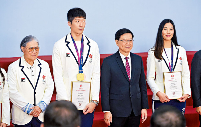 李家超（右二）向在亞運中獲獎的運動員頒發表揚狀。左二及右一為劍擊運動員張家朗與陳渭泠、左一為奧委會會長霍震霆。