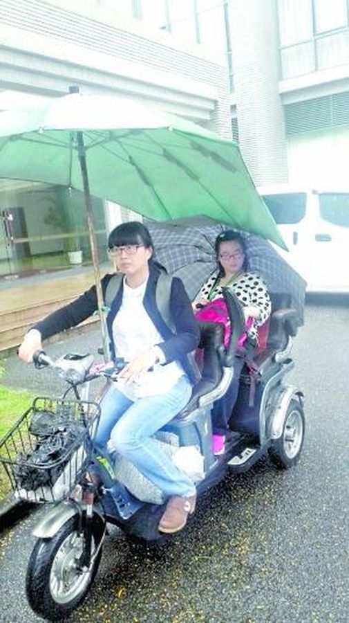 黄惠鹂风雨不改驾电单车送女上学。
