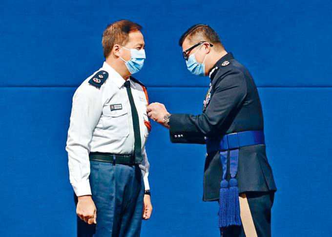 ■警务处处长邓炳强（右）向参与特别行动的人员，颁授「香港警察特别行动奖章」。