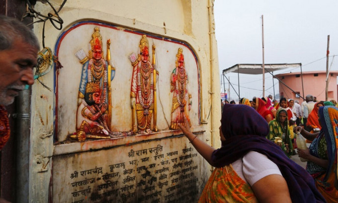 阿約提亞的印度教徒觸摸牆上的印度教三大主神像。AP圖片
