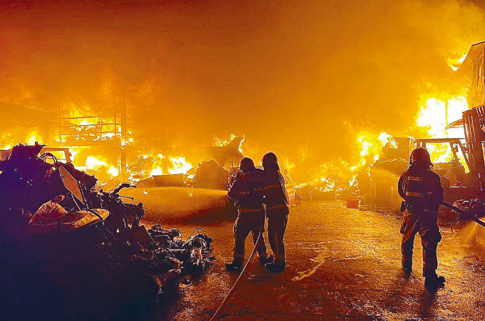 八乡一劏车场失火，火光熊熊，消防员开喉灌救。