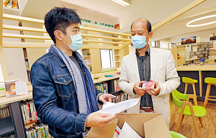 新界喇沙中學校長曹紹民（右）接收流動數據卡。