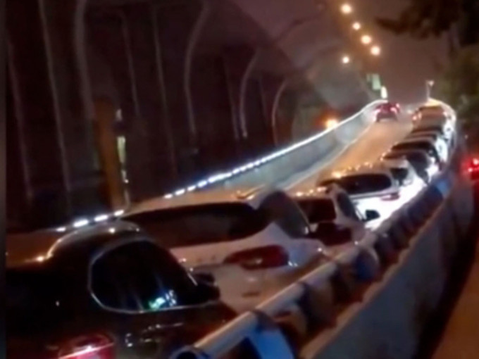 郑州发暴雨预警后，市民将私家车泊满高架桥上。