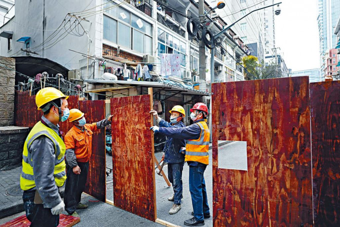 上海浦西今起「封城」，小区工人昨天加装围板。