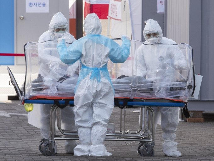 在首爾，醫護人員將一名患者轉送至醫院。（新華社圖片）