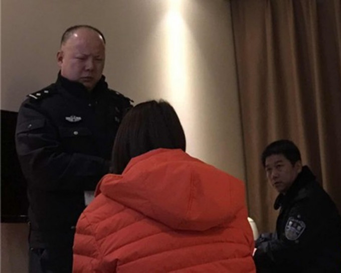 小王（红衣）被骗后向警察求助。影片截图