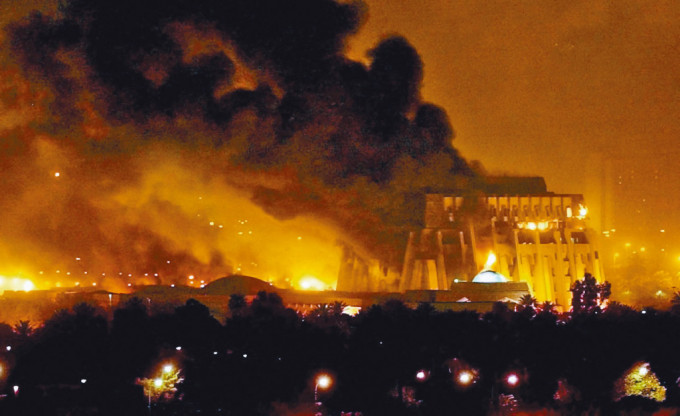 巴格達2003年遭空襲，建築物着火焚燒。　