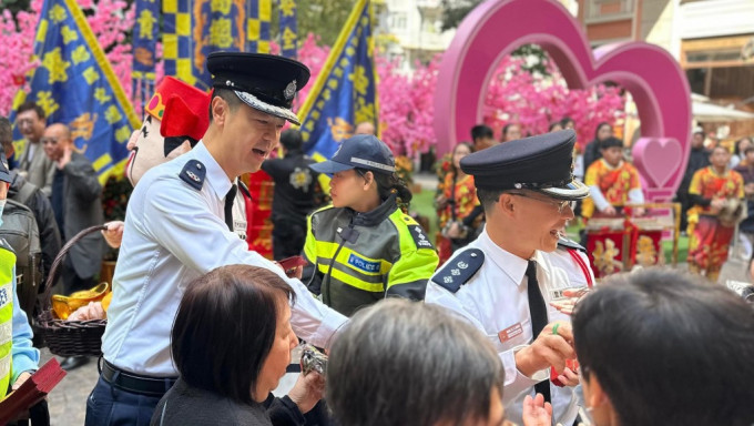 港島總區指揮官郭嘉銓(左)及港島總區副指揮官林鴻釧(右)於灣仔利東街向市民派發紀念品。