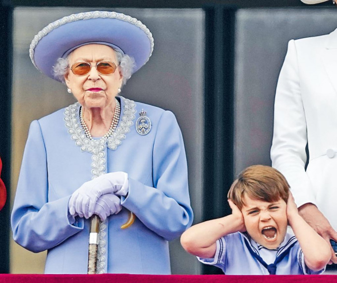 英女皇周四在白金汉宫露台看飞行表演，威廉王子幼子路易王子因机声嘈杂双手捂耳大叫。