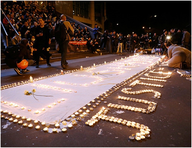 事发后，华人群体聚集在巴黎，点烛悼念遭枪杀的刘少尧。网图