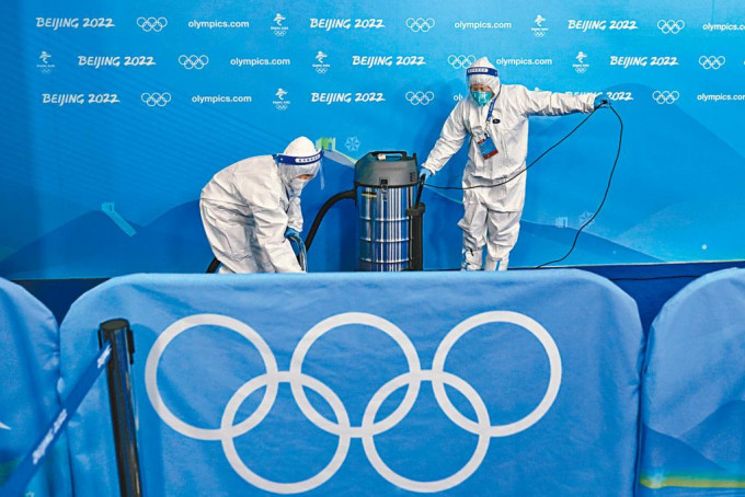 身穿防護服的冬奧人員正在清潔會場。