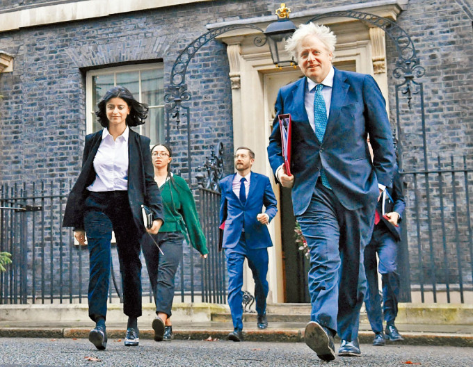 约翰逊前年十二月与政策负责人米尔扎（左），步出伦敦首相府。